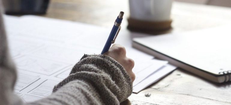 A woman writing down all the ways Google My Business helps your business.