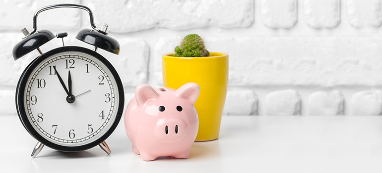 Clock, piggy bank, and office plant
