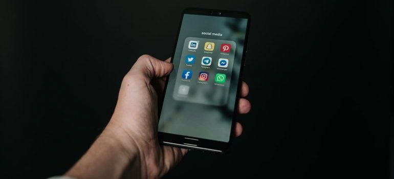Hand holding a smart phone with social media networks