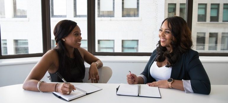 Two women having a conversation in an office.