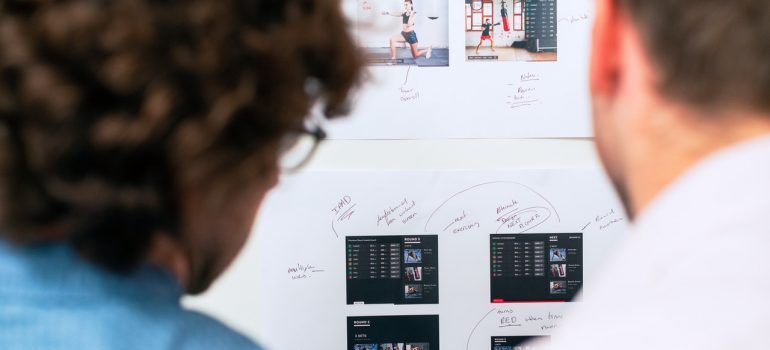 Two guys looking at whiteboard with software blueprints.