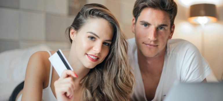 Young couple with a laptop and credit card.