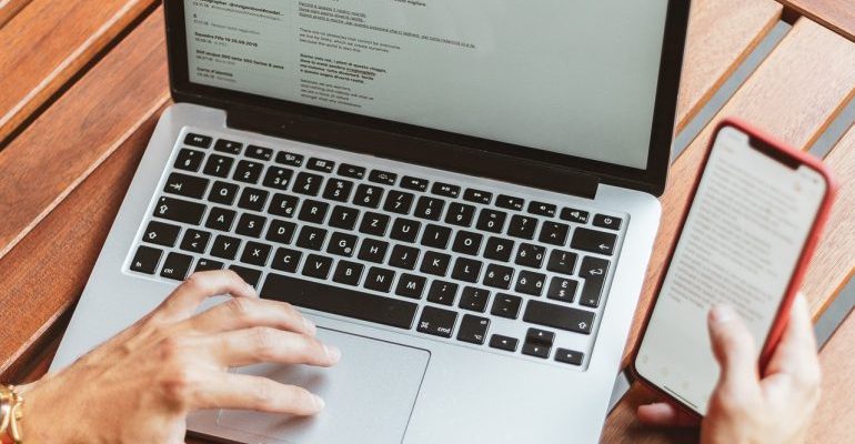 Emails on laptop screen and phone.