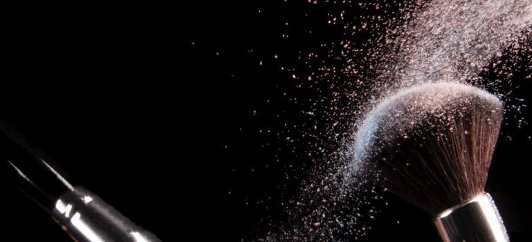 Two brushes colliding in front of a balck background.