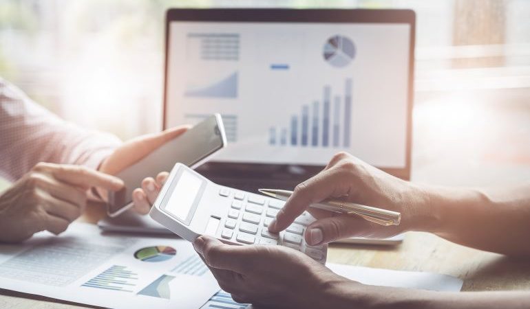 Two persons looking at stats and doing calculations.