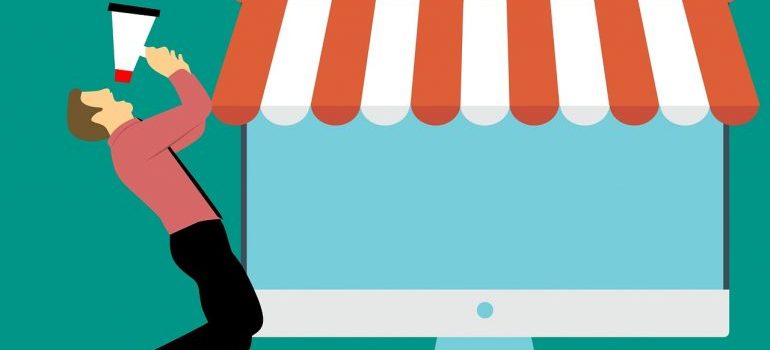 A man with a megaphone next to a computer screen.