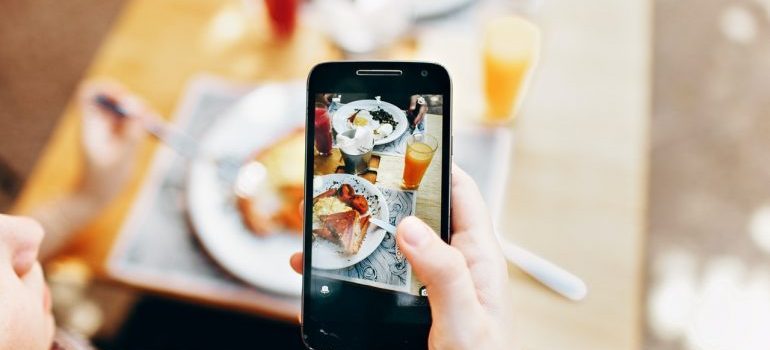 A person taking a photo of food to share online because the food industry is among the top industries that benefit from digital marketing