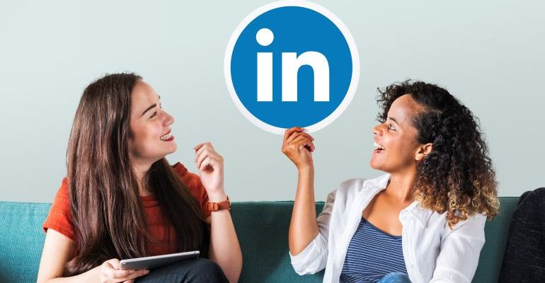 Two women on a couch, holding the LinkedIn logo