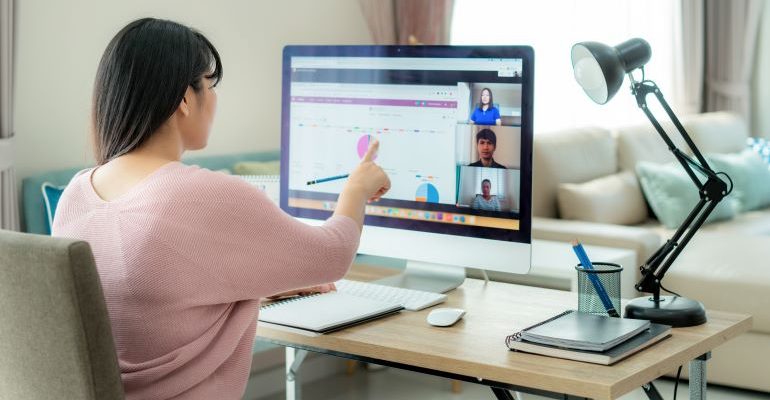 Person looking at laptop while attending an online meeting.
