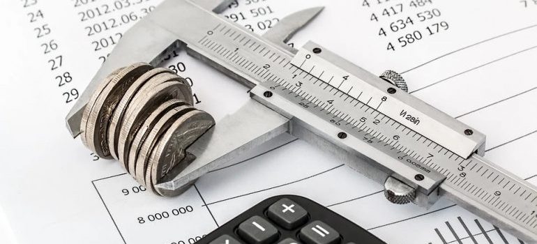 A stack of coins measured with a ruler over papers.