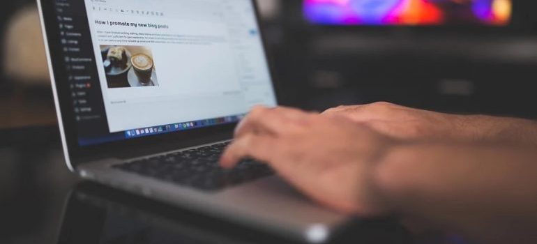 A person wring an article on WordPress on a laptop.