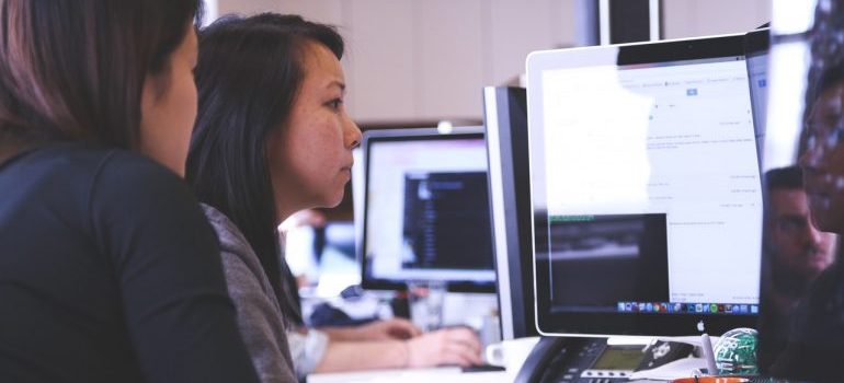 dvo women looking at a desktop computer screen