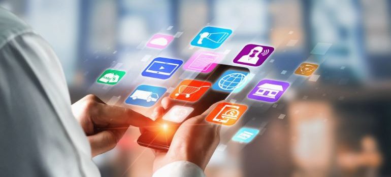 Person looking at smartphone with different floating icons.