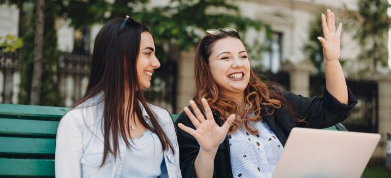 Two women discussing storytelling marketing on a bench in a park.
