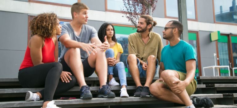 Person telling a story to friends outside.