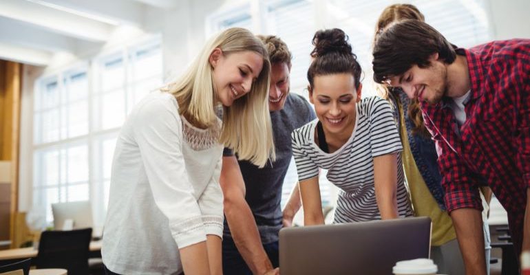 Team of people looking at a laptop.