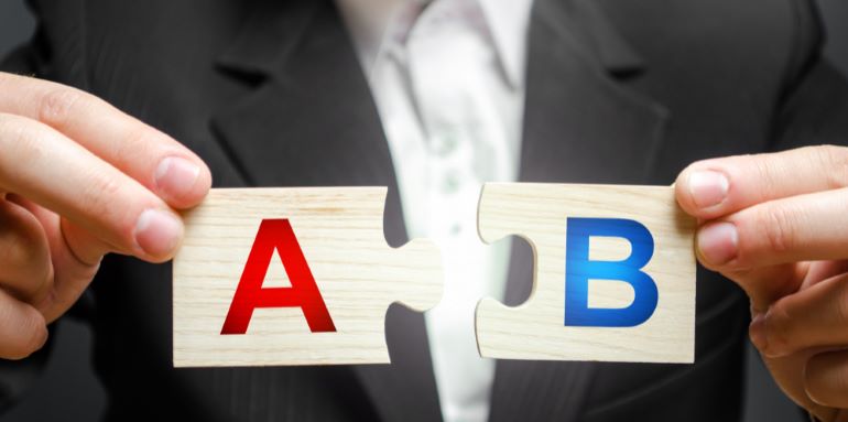Businessman holding two puzzle pieces marked with A and B.