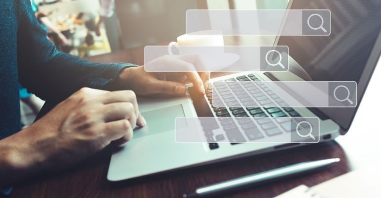 Person typing on laptop, with multiple search bars around.