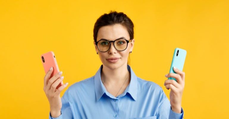 Woman holding two phones.