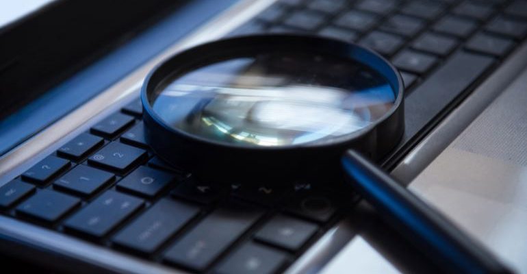 A magnifying glass on a keyboard.