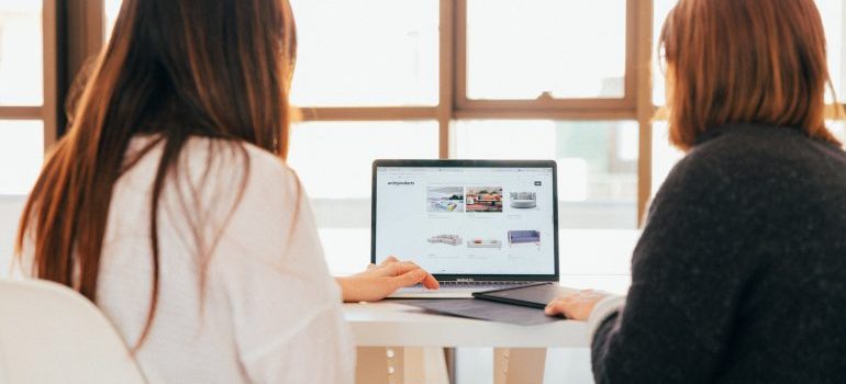 two women browsing through a webiste, representing website navigation practices