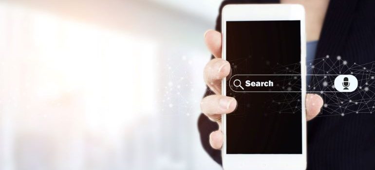 Businesswoman holding a phone with voice search bar on the screen.