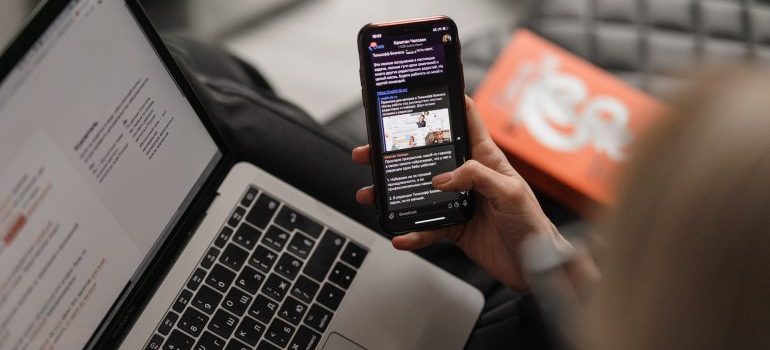 Person using phone app and computer.