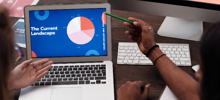 People looking at a pie chart on a laptop screen.