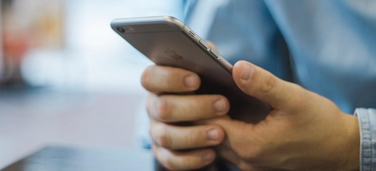 Person using Apple smartphone to read email marketing.