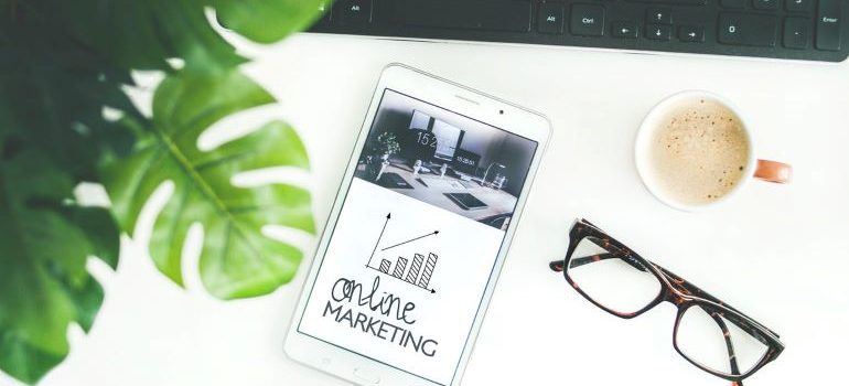 Online marketing on tablet with glasses and keyboards.