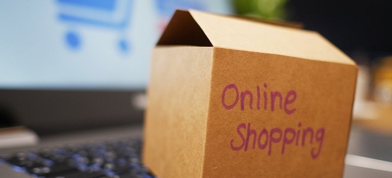 Crate for online shopping resting on laptop.