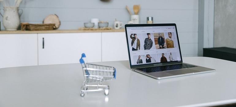 Shopping cart next to laptop.