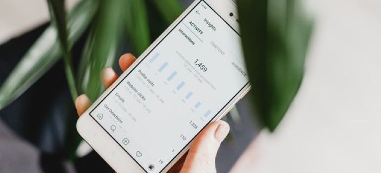 Photo of a person holding a phone and looking at Instagram Insights