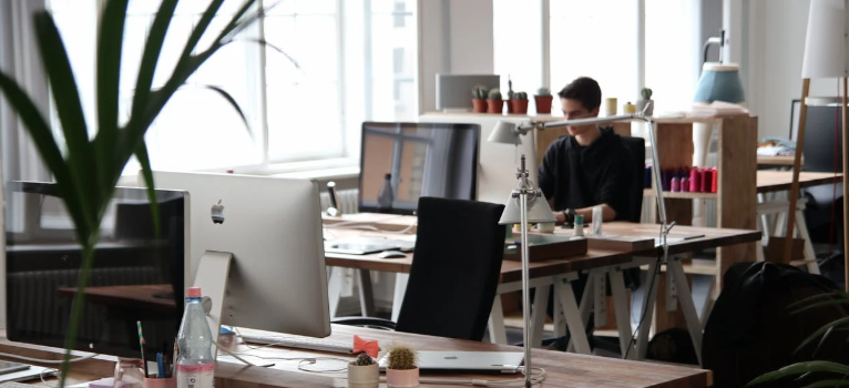  Interior of a business with tables, computers, and a man working