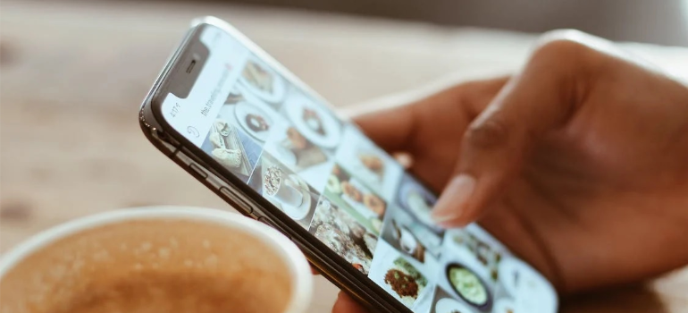 A selective focus photo of a person using social media on their phone.