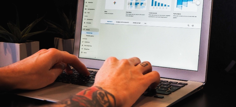 Person typing on a laptop and using Google Analytics