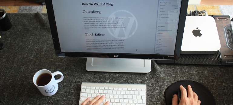 Person typing a blog post in WordPress using an iMac