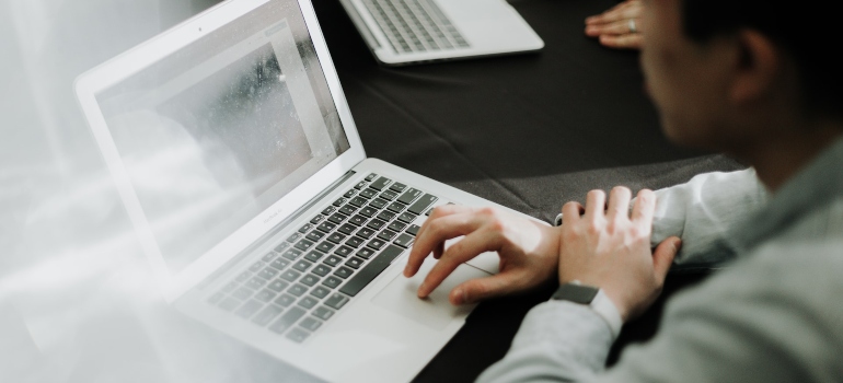 Person typing on a white laptop 