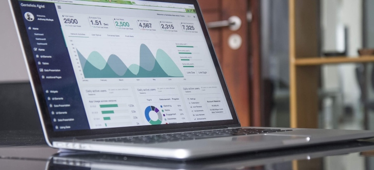 A laptop on a desk with website metrics page opened on it