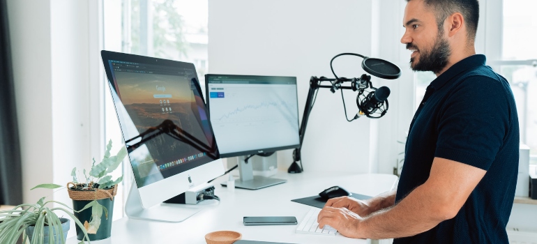 Man wearing a black t-shirt filming and editing content for his social media platforms