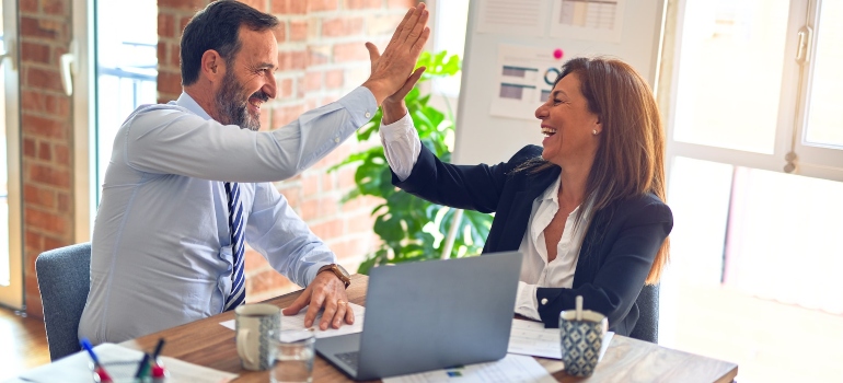 Two people high-fiving each other after a meeting