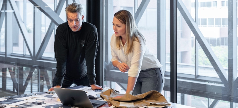 Man and a woman reviewing SEO strategies in an office with large windows