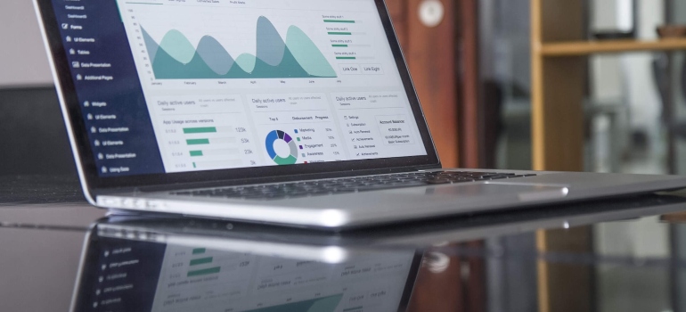 Laptop with charts on it on a glass table