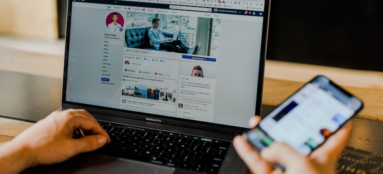 Person using Facebook on both their laptop and their smart phone