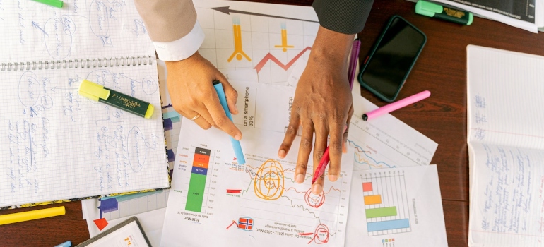 Person analyzing data and highlighting important things on papers