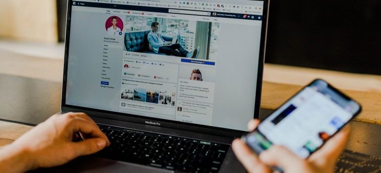 A person using facebook on their phone and laptop.