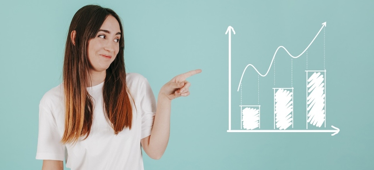 Woman wearing a white t-shirt pointing at a chart