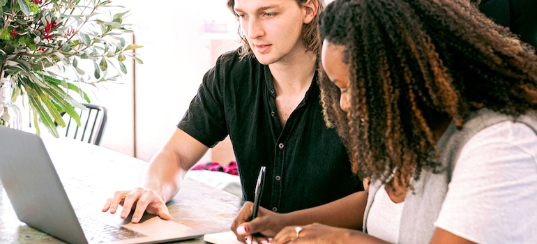 Two people using a laptop