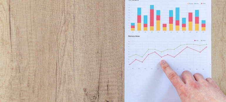 Finger pointing at charts on a paper