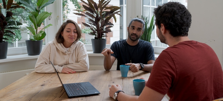 Three people discussing rehab marketing strategy during a meeting